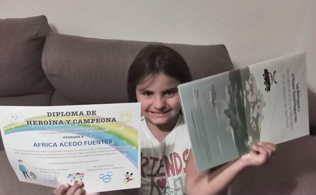 Imagen principal - África y Ainara con sus diplomas y libros. 