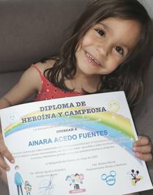 Imagen secundaria 2 - África y Ainara con sus diplomas y libros. 