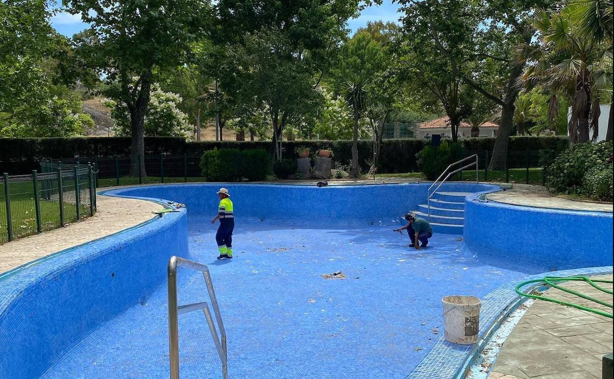 Trabajadores municipales realizando trabajos en uno de los vasos de la piscina municipal. 