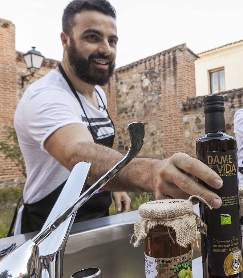 El cantante Huecco entregando una botella de aceite 