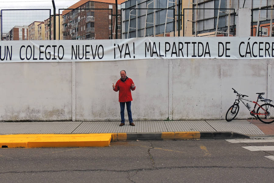 El poeta Plácido Ramírez Carrillo bajo la pancarta 'Un Nuevo Colegio 'Ya' Malpartida de Cáceres'. 