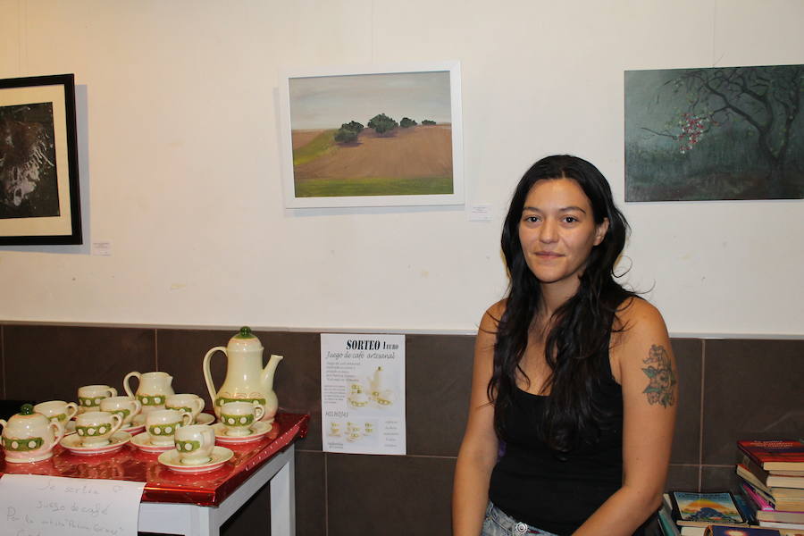 Patricia Gómez junto a varias de sus obras, incluidas las piezas de café realizadas por ella a mano que sortea entre su público asistente por un euro. 