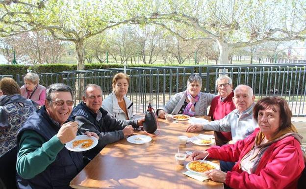 Los participantes degustan un plato de migas 