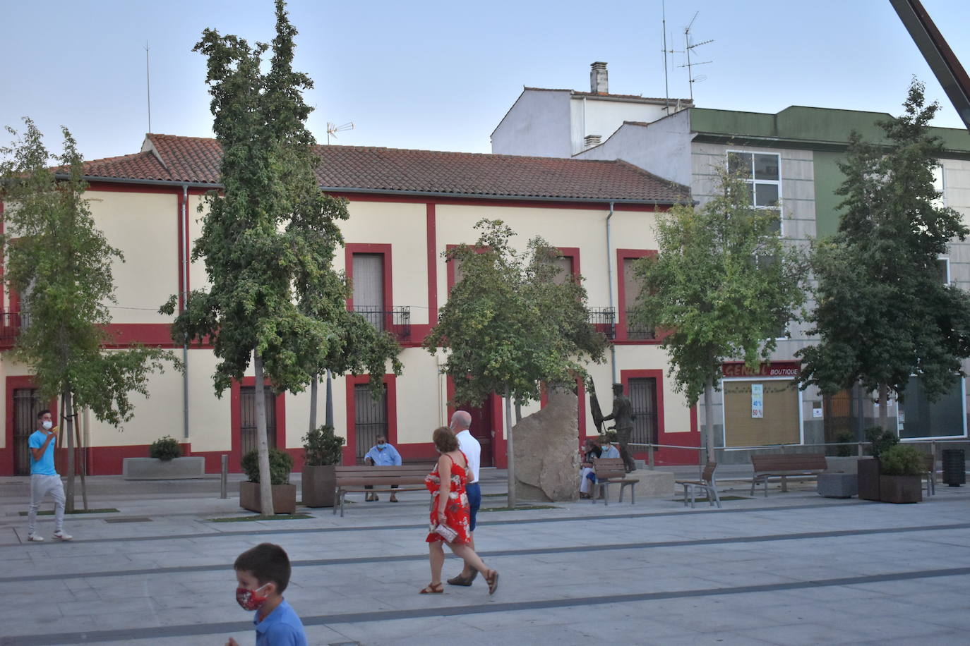 Vecinos sentados o paseando por la Plaza de España de Miajadas 