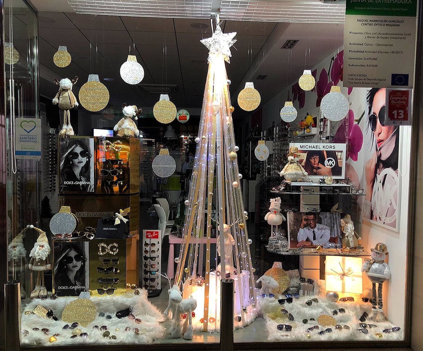El escaparate de Centro Óptico Miajadas está lleno de bolas de Navidad en oro y plata 