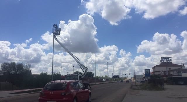 Un operario sustituye una de las luminarias de la carretera de salida de Miajadas hacia Don Benito 