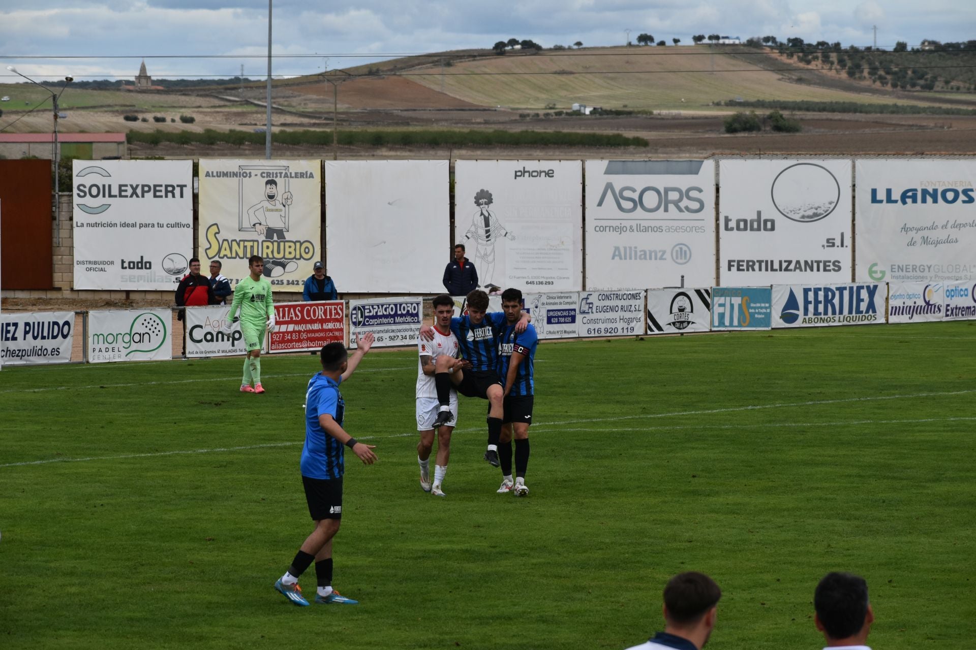 Ejemplo de compañerismo: dos jugadores contrarios sacan en brazos a otro tras lesionarse.