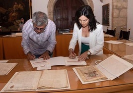 El alcalde, Antonio Díaz, firma la recepción de los documentos restaurados.
