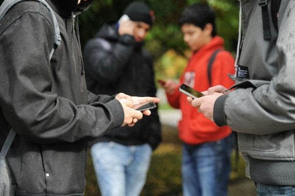 Un grupo de adolescentes se afana con sus móviles en un chat colectivo. 