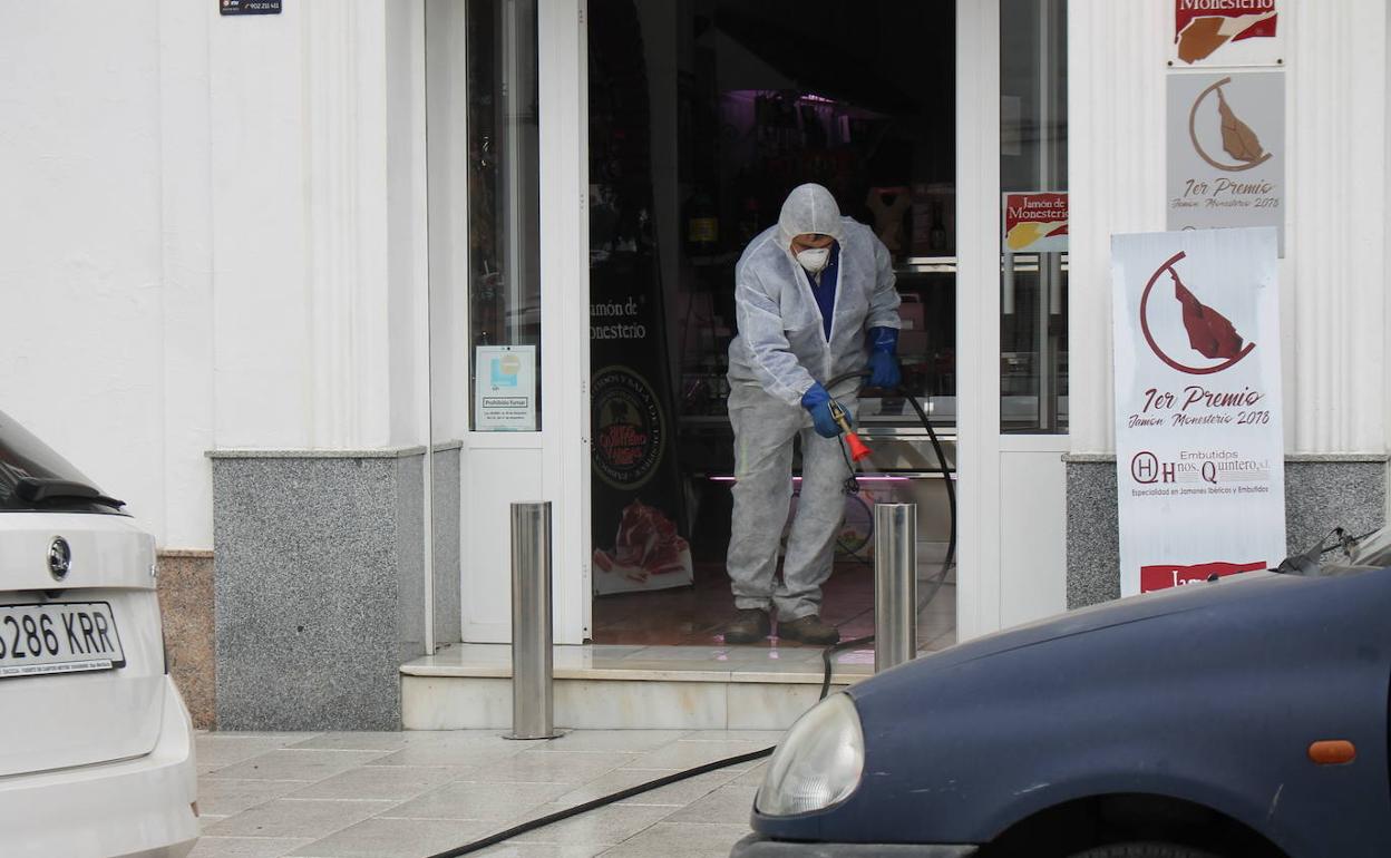 Un operario municipal desinfecta la entrada de Embutidos Hnos Quintero 