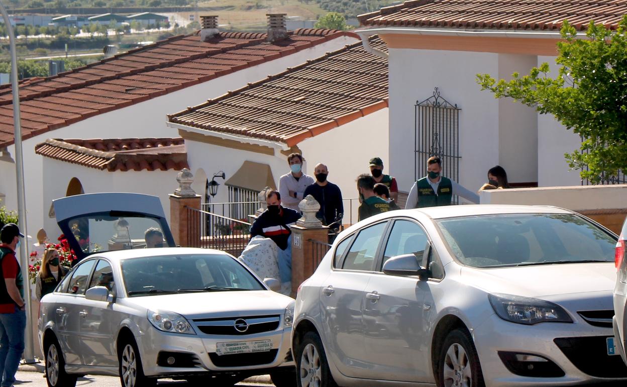 Eugenio D., acusado de la muerte de Manuela Chavero, sale de su casa mientras sostiene un maniquí que simboliza el cuerpo sin vida de la vecina, envuelto en una sábana, durante la reconstrucción de los hechos llevada a cabo este viernes.