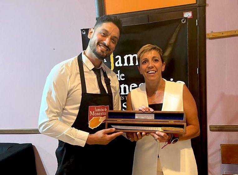 Javier Torres recibe el Cuchillo Jamonero de Oro de manos de Loli Vargas, alcaldesa de Monesterio