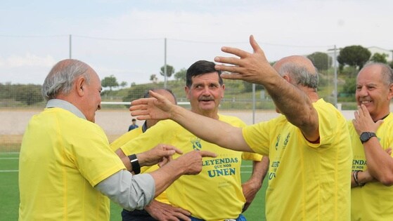 Momento de un abrazo entre compañeros con la camiseta amarilla del C. P. Monesterio