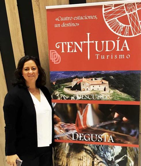 Mercedes Díaz junto a un cartel promocional de Turismo en Tentudía