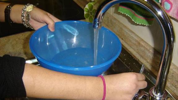 Una mujer llena un baño de agua del grifo 