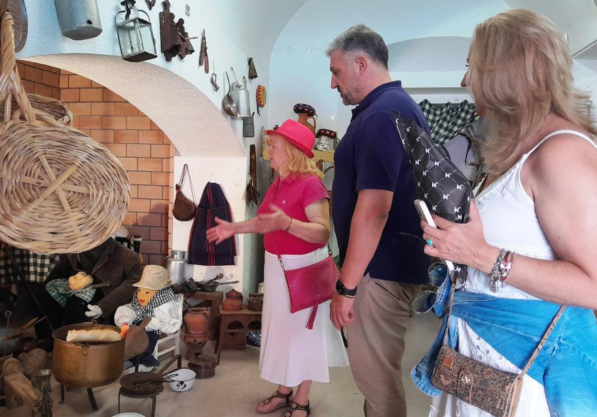 Angelines mostrando el minimuseo a una pareja de visitantes