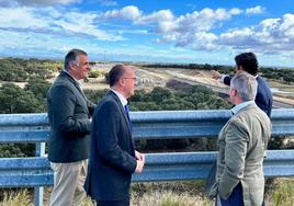 El consejero, de espaldas junto al alcalde, observando las obras del tren