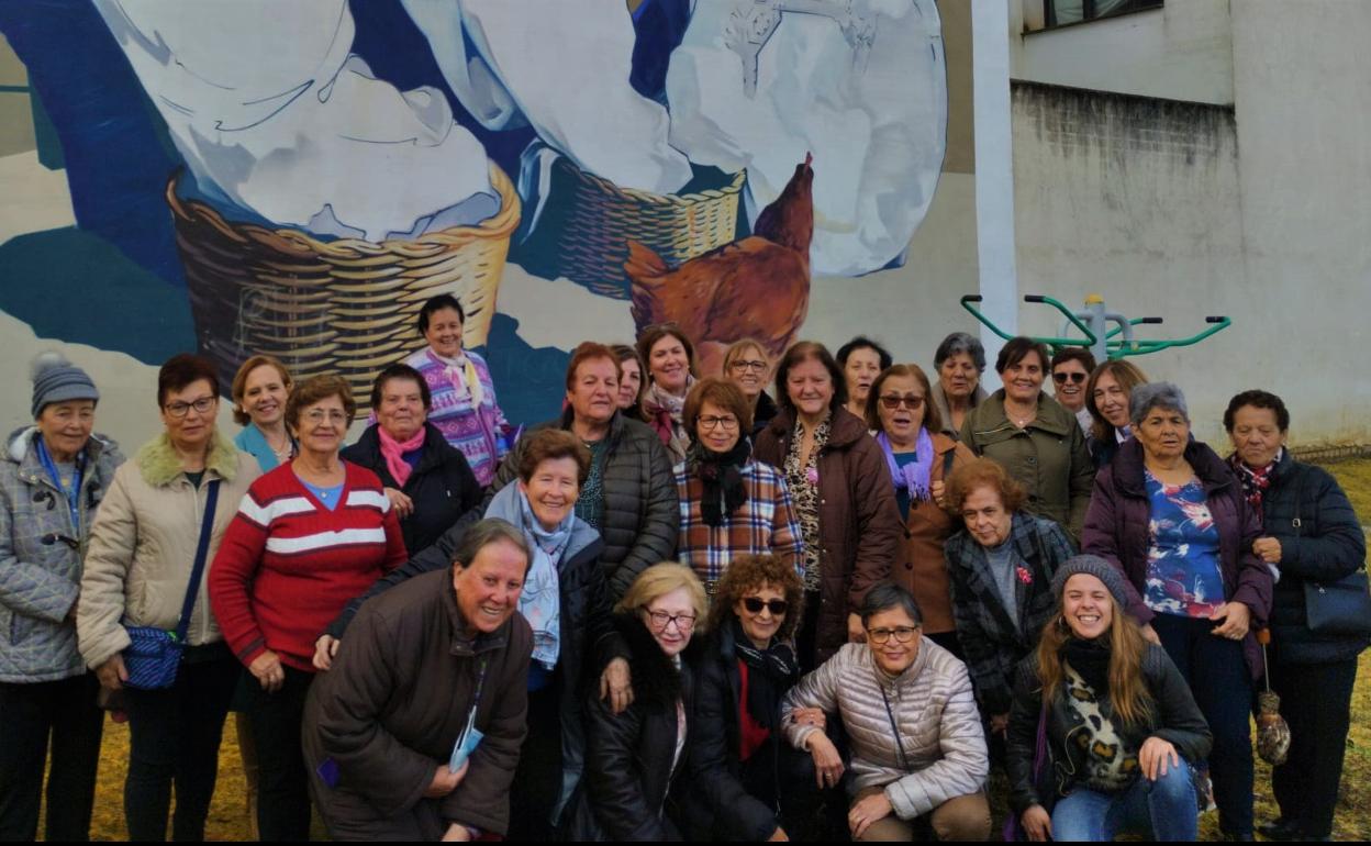 Mujeres de la población frente al mural dedicado a las costureras, una de las paradas de la ruta. 