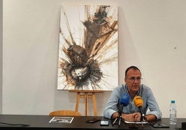 Enrique Hueso con el cartel anunciador de San Miguel