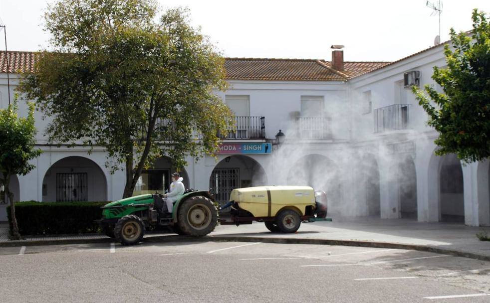 Un agricultor colaborando con su tractor en las labores de desinfección. 