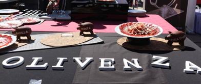 Imagen secundaria 1 - Arriba, momento de la cata de vinos de denominación de origen Ribera del Guadiana. Abajo, concurso de corte de jamón, con el ganador Daniel Acedo en acción. 