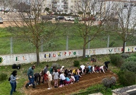 Los escolares realizando las labores de cuidado del huerto.