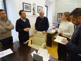 El regidor ojea el libro recién restaurado.