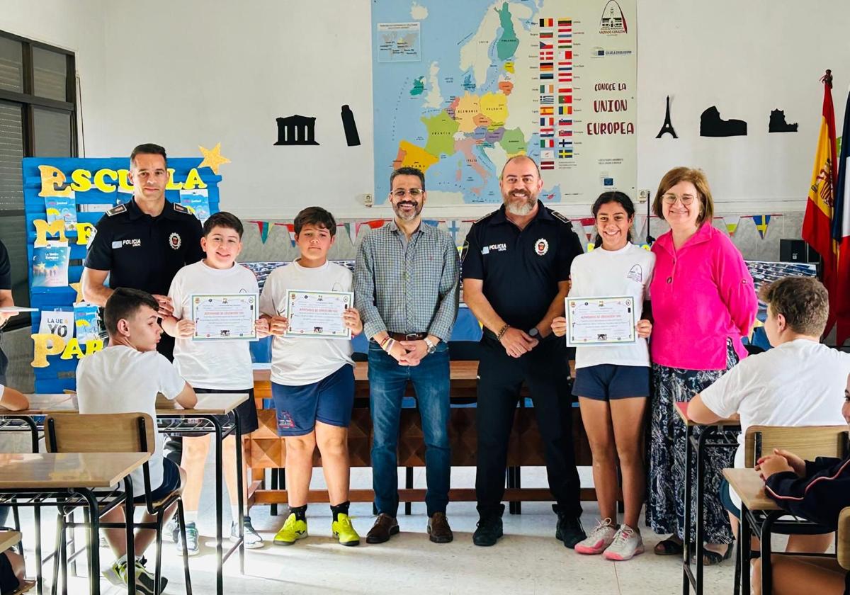 Los escolares muestran sus diplomas junto a los agentes y el regidor local.