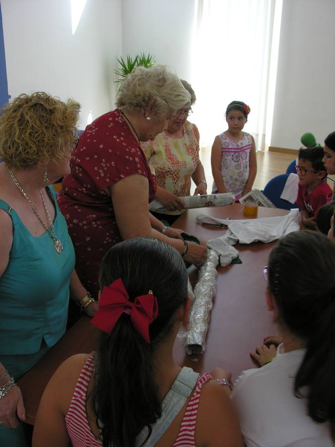 Mujeres de AMO muestran los primeros pasos para la elaboración de la muñeca. 