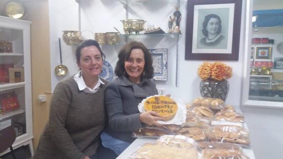 Carmen Pilar y Celestina Mª Rodríguez, junto al retrato de su madre, Carmen Fuentes, en el mostrador de la tienda. 
