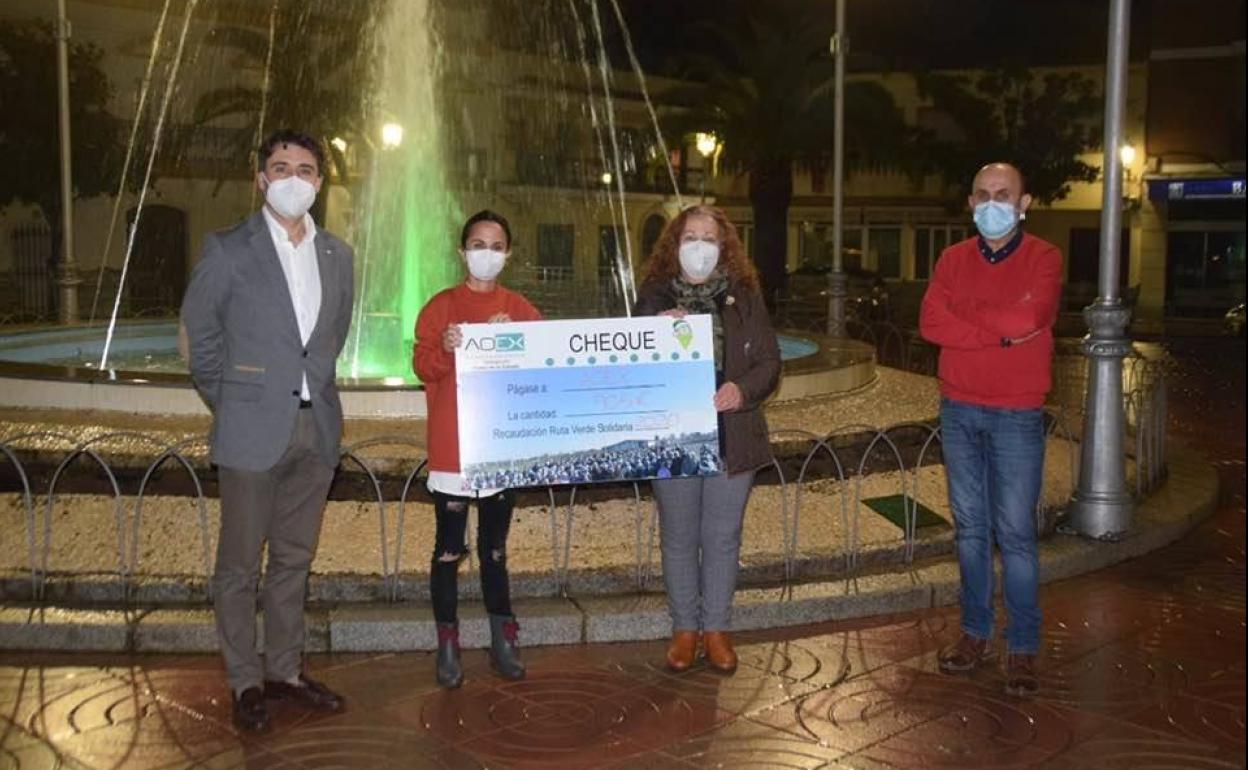 Juan Mari Delfa, alcalde (izquierda), y José Pérez, concejal de Deportes y Participación Ciudadana (derecha) entregan el cheque a dos miembros de AOEx (centro)