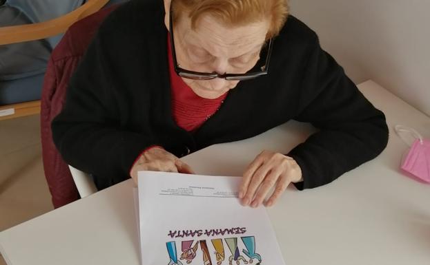 Una usuaria trabaja con el cuadernillo de pasatiempos 