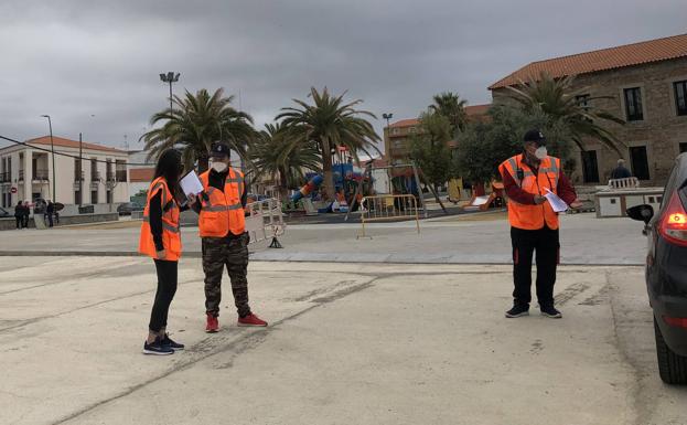 Los voluntarios de Proteción Civil pasan lista e indican la entrada a los coches 
