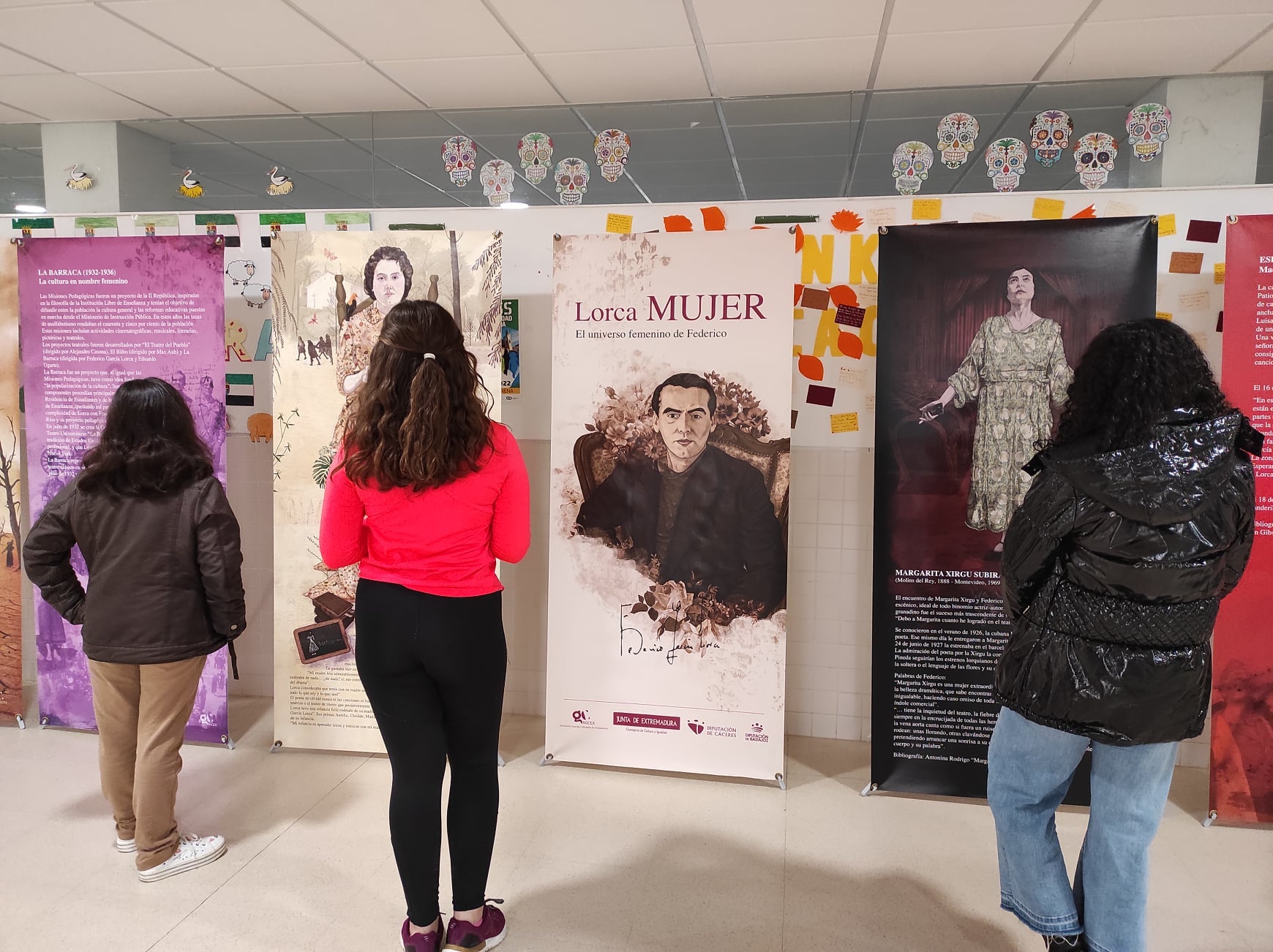 Alumnas del centro observan los paneles de la exposición 