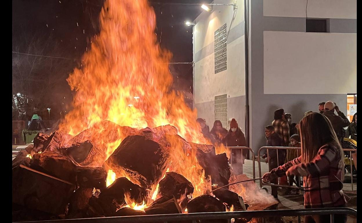 Una vecina quemando un trozo de corcho en la hoguera