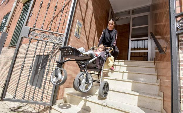 Carmen Miralles subiendo las escaleras de acceso a su casa con su hijo Giovanni.