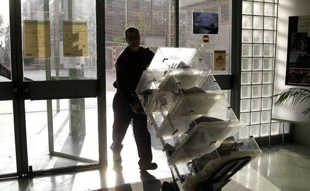 Operario transportando urnas a un colegio.