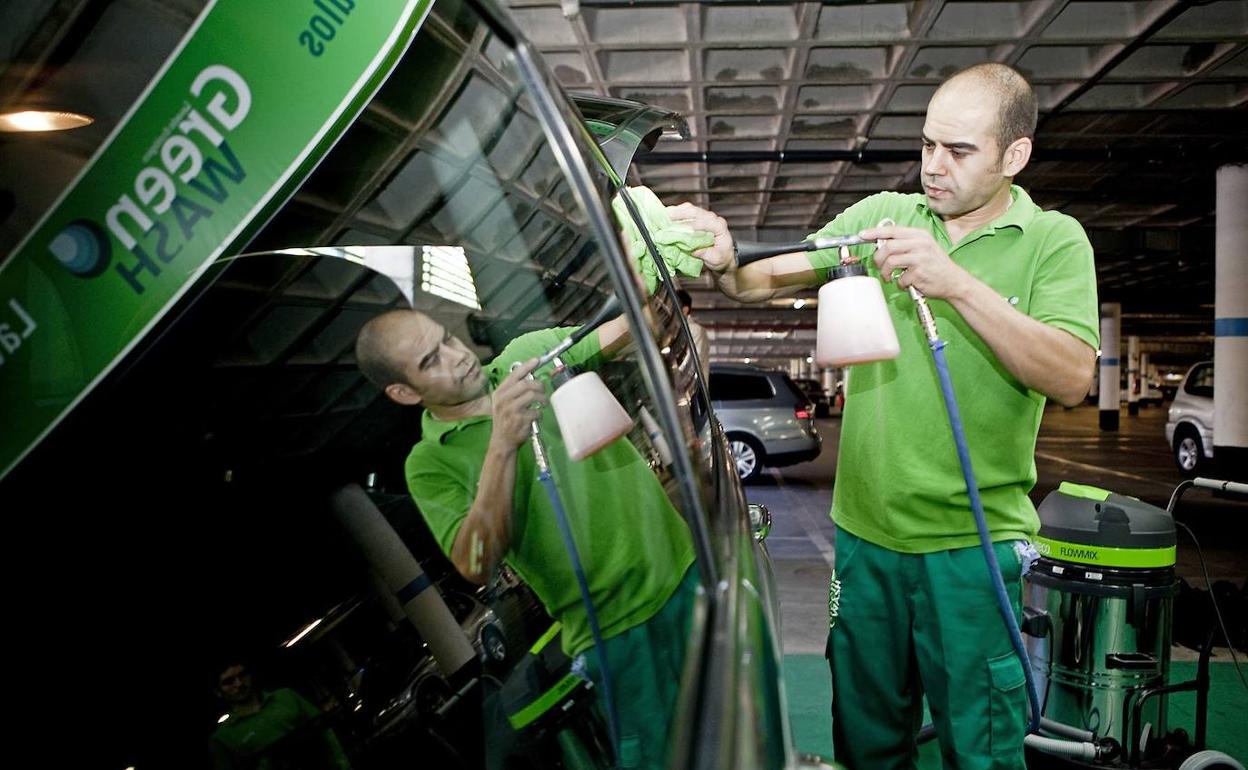 Persona con un 33% de discapacidad física trabajando en un lavadero. 