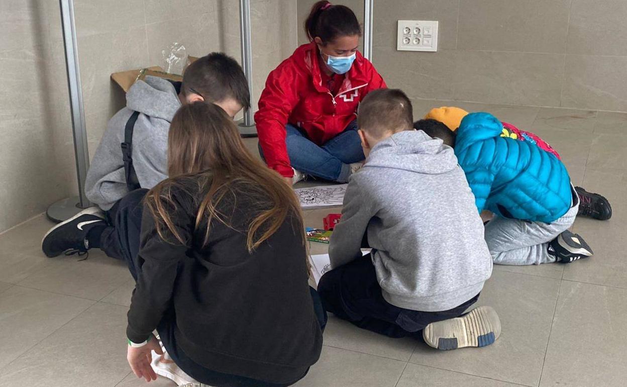 Voluntaria de Cruz Roja jugando con refugiados llegados a Extremadura. 