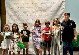 Los ganadores posan junto a las tazas que llevan sus dibujos.