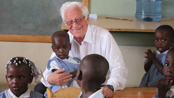 Ángel García, sacerdote y presidente de la fundación española Mensajeros de la Paz, posa con un grupo de niños en una escuela de Haití.