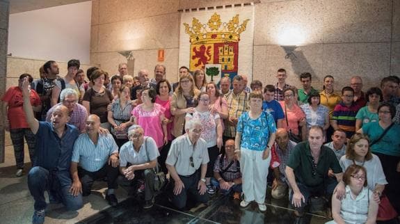 Usuarios de Placeat tras la entrega del tapiz en la Asamblea de Extremadura.