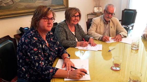 Rosario Cordero, en el centro, y Francisco Valverde durante la firma del convenio.