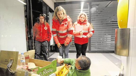 Voluntarios de Cruz Roja atendiendo a personas que viven en la calle.