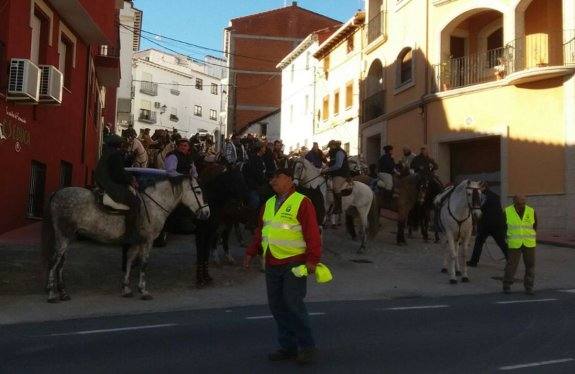 Jinetes asistentes aguardando para cruzar la carretera. 