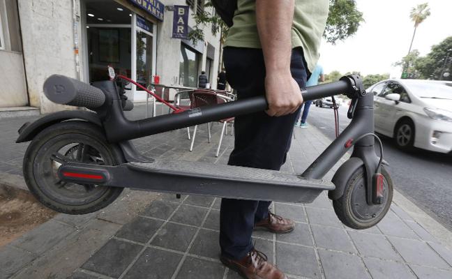 Un hombre con su patinete eléctrico. 