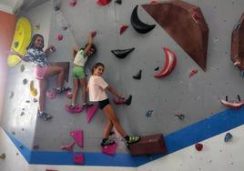 Tres jóvenes usuarias practicando la escalada en el nuevo rocódromo, ayer.