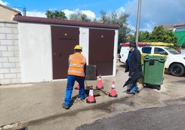 Operario trabajando en la sustitución del cuadro, junto al concejala Eduardo Diz.