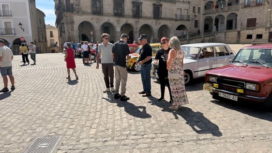 Vecinos junto a coches participantes.