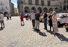 Vecinos junto a coches participantes.